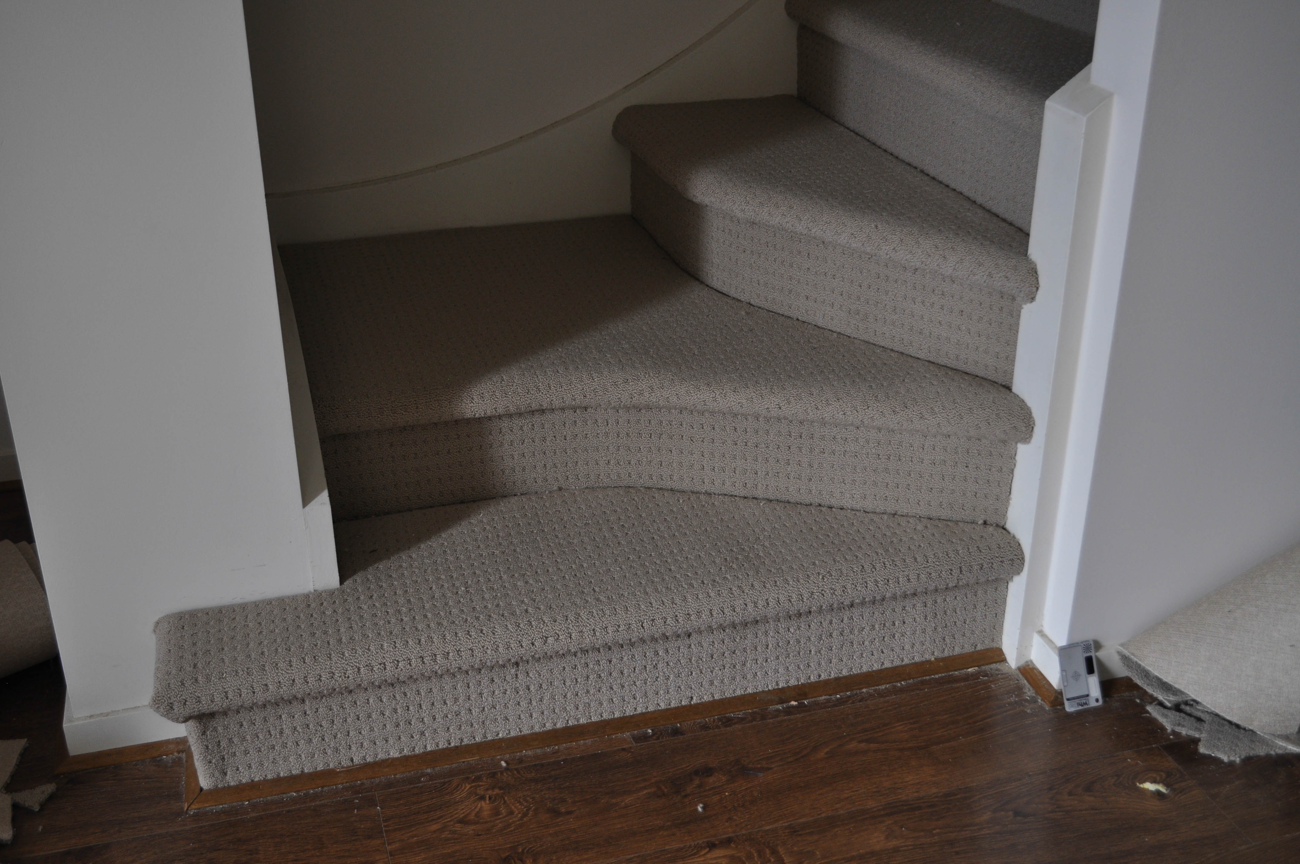 showing a staircase in which the carpet store Concord floors installed a patterned modulated loop-pile carpet of a light beige color, which has a rating of residential heavy duty including stairs