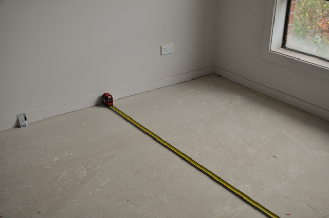 a room being measured widthwise for carpet laying by Concord Floors in a house in Werrbee.