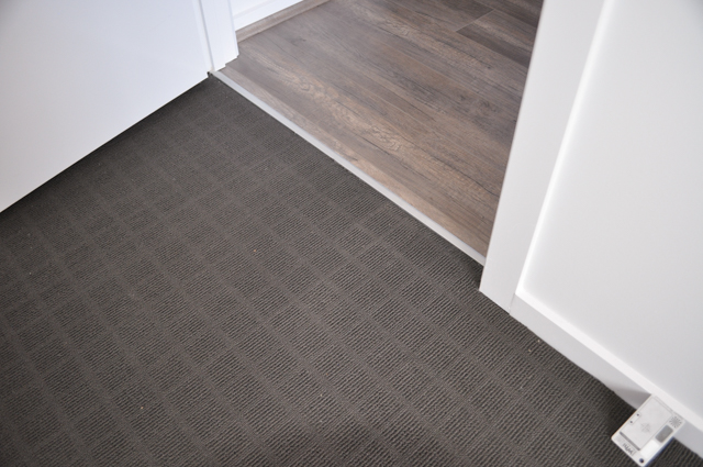 a sample of charcoal colored, modulated loop pile carpet.